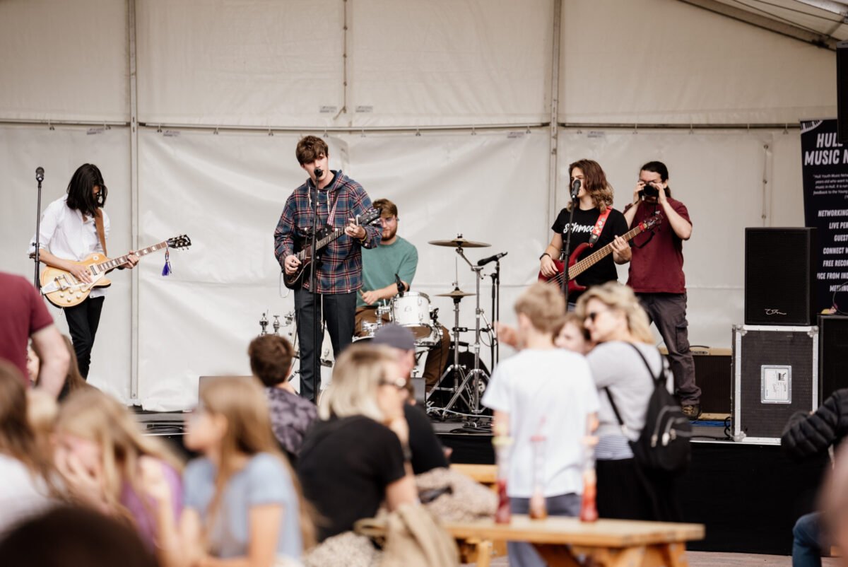 Young audience members watching musicians perform at a cultural event