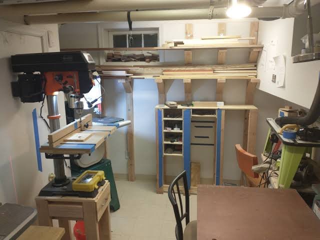 A well-organized, budget-friendly home woodworking workshop featuring neatly arranged modular tools and a sturdy workbench.